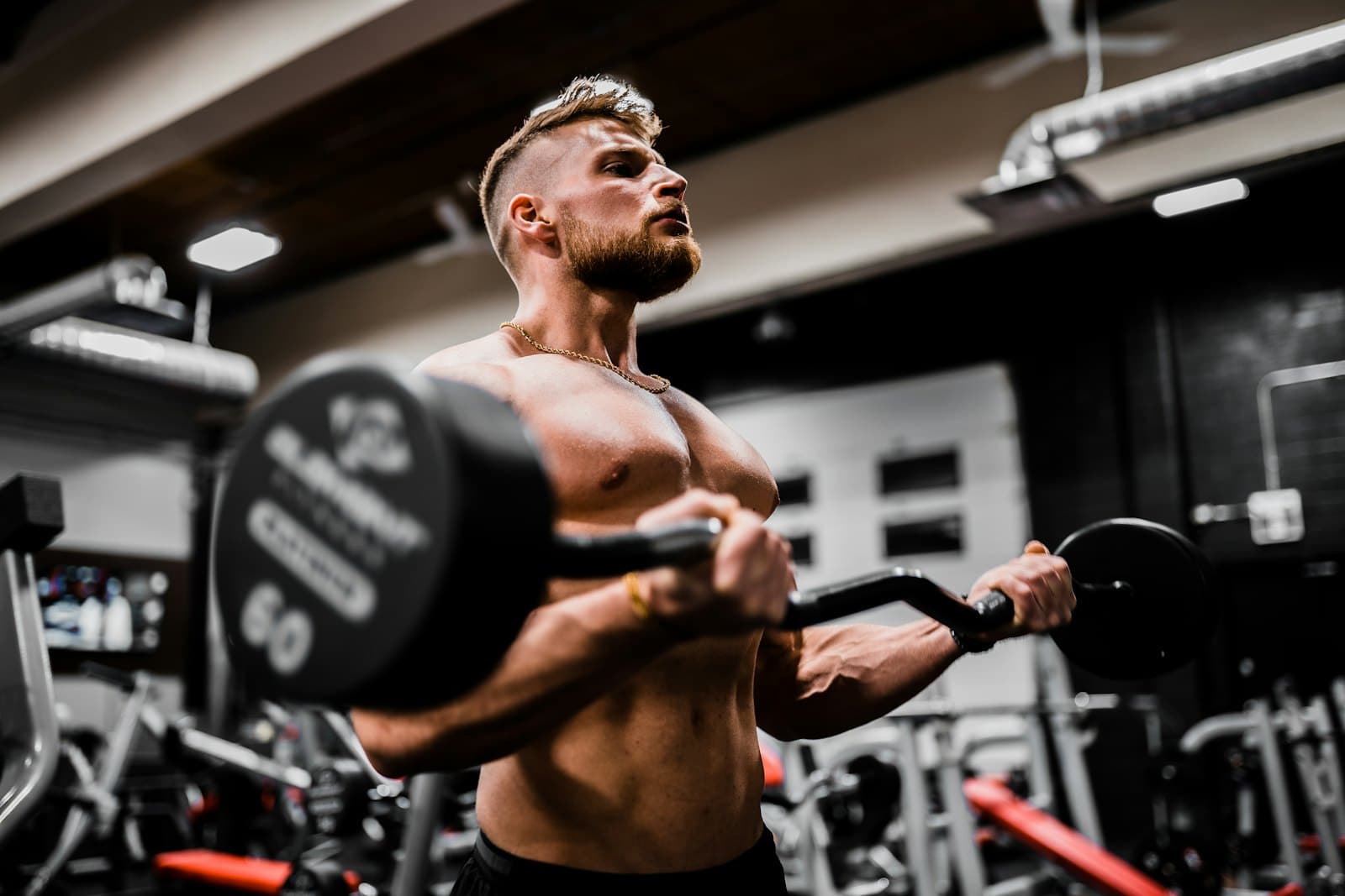 Man doing a barbell curl in a gym